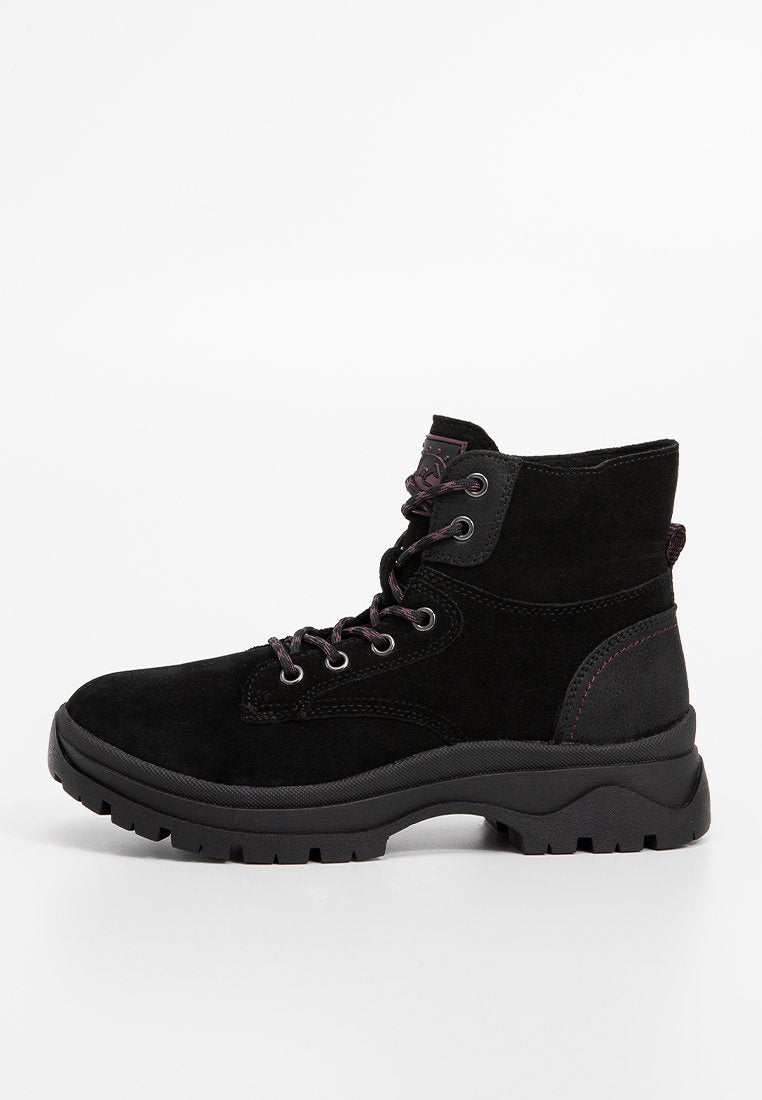 Schwarze Wildleder-Ankle-Boots mit dicker Gummisohle, schnürbarer Vorderseite mit Metallösen und dezenten lila Nähten.