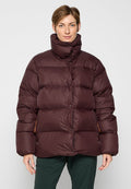 Burgunderfarbene Pufferjacke mit hohem Kragen, ausgestattet mit einem gesteppten Design, sichtbaren Knöpfen und orangefarbenen Akzenten an den Seitentaschen.