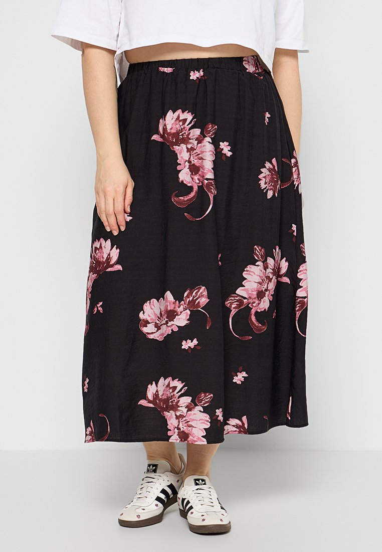 Schwarzer Midirock mit rosa Blumenmuster, elastischem Bund, leichter Stoff, kombiniert mit weißen Sneakers mit schwarzen Akzenten.