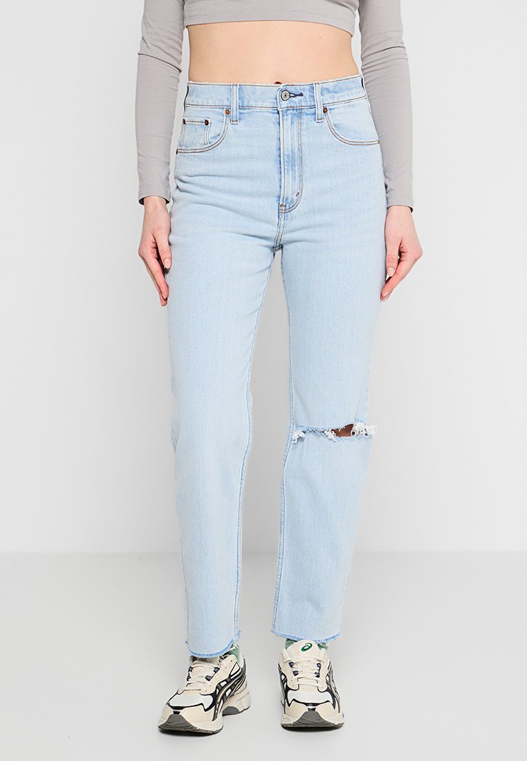 Hellblaue Hochwasserjeans mit geradem Schnitt, mit einem ausgefransten Knie, klassischem Fünf-Taschen-Design und Metallknopfverschluss.