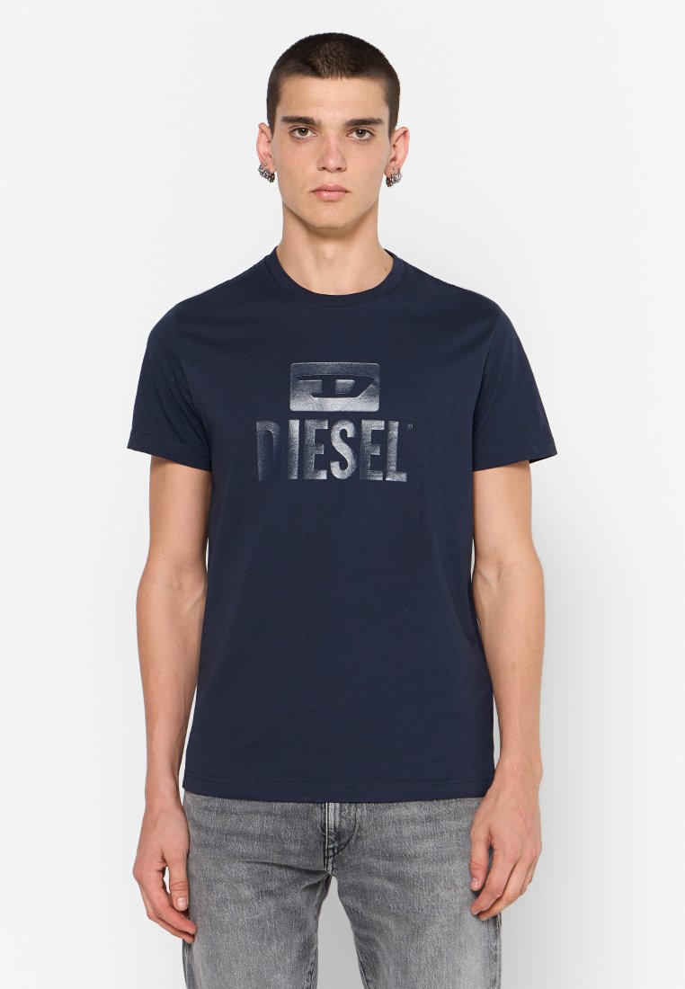 Navyblaue Baumwoll-T-Shirt mit einem metallischen "DIESEL"-Logo in der Mitte. Kurze Ärmel, Rundhalsausschnitt und weiche Textur.