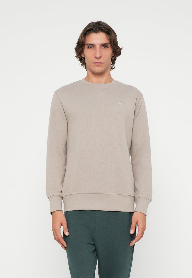 Hellbeiges Sweatshirt mit Rundhalsausschnitt, gerippten Bündchen und Saum, mit einem kleinen gestickten Logo auf der Brust. Weicher, glatter Stoff.