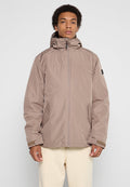 Hellbraune Kapuzenjacke mit Reißverschluss, ausgestattet mit seitlichen Taschen, elastischen Bündchen und einer glatten, matten Oberfläche. Einfaches Design mit minimalen Akzenten.