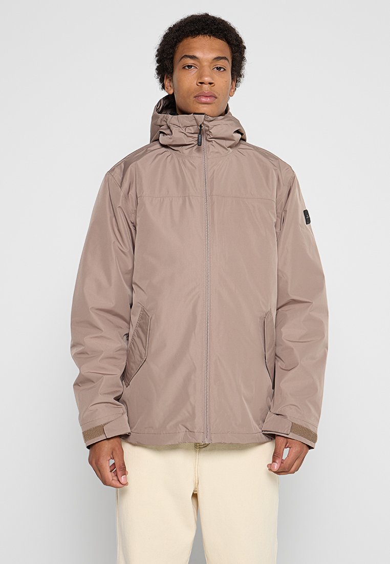 Hellbraune Kapuzenjacke mit Reißverschluss, ausgestattet mit seitlichen Taschen, elastischen Bündchen und einer glatten, matten Oberfläche. Einfaches Design mit minimalen Akzenten.
