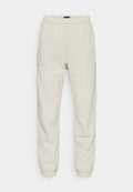 Cremfarbene Sweatpants aus weichem Material, mit einem elastischen Bund, Seitentaschen und Bündchen an den Knöcheln.