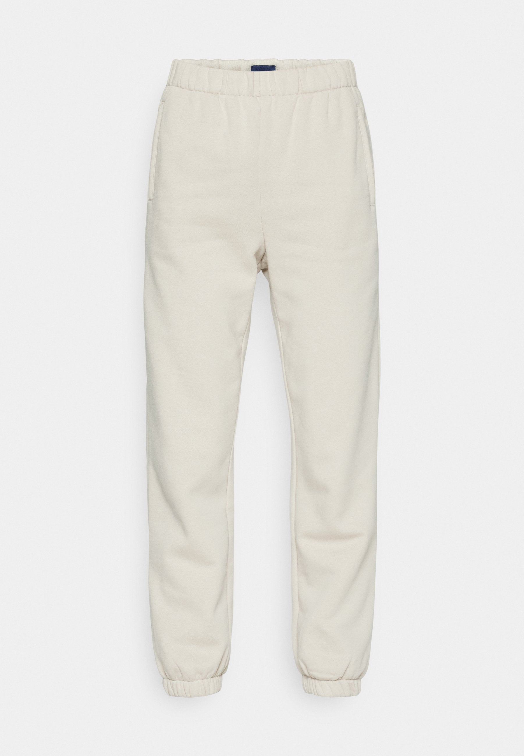 Cremfarbene Sweatpants aus weichem Material, mit einem elastischen Bund, Seitentaschen und Bündchen an den Knöcheln.