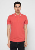Rotes Poloshirt mit weißgestreiftem Kragen und kurzen Ärmeln, mit drei Knöpfen und einem kleinen Logo auf der Brust. Glatte Baumwolltextur.