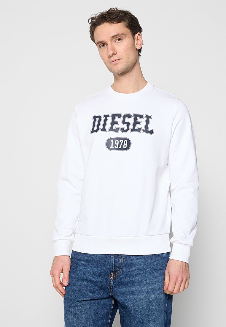 Weißer Sweatshirt mit gerippten Bündchen und Saum, mit einem marineblauen aufgedruckten Logo "DIESEL 1978" auf der Vorderseite. Kombiniert mit blauen Jeans.