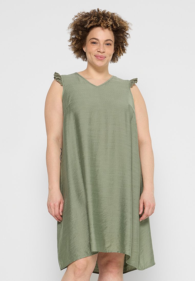 Olivegrünes, ärmelloses Kleid mit V-Ausschnitt, das voluminöse Akzente an den Schultern und einen fließenden, asymmetrischen Saum aufweist. Glattes, strukturiertes Material.