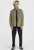 Grüne Fleecejacke mit hohem Kragen, Frontreißverschluss und Brusttasche. Schwarze Hose und graue Sportschuhe vervollständigen das Outfit.