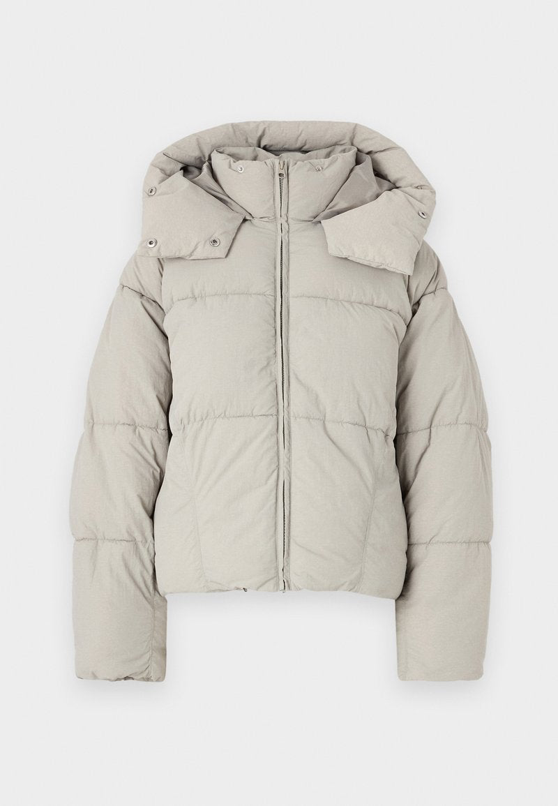 Hellgraue, kurz geschnittene Pufferjacke mit hohem Kragen, Reißverschluss, Druckknöpfen und gestepptem Design. Mit weiten Ärmeln und Kapuze.