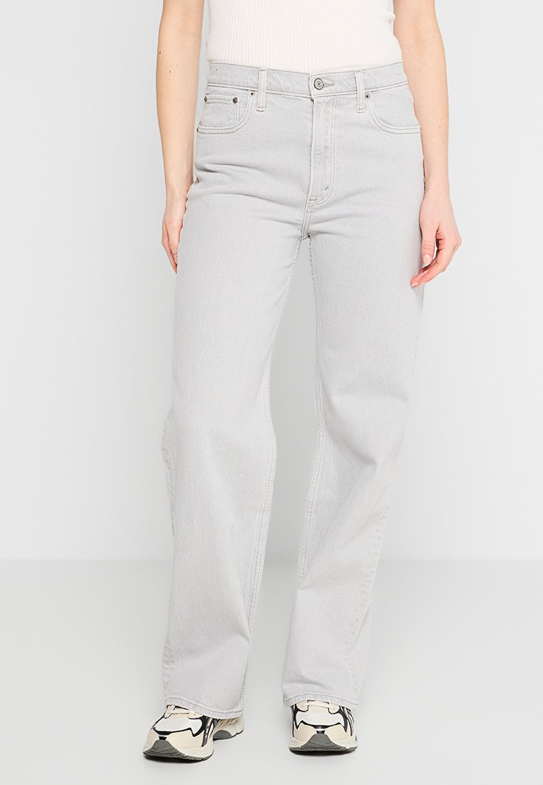 Helle graue Denim-Jeans mit geradem Schnitt, Fünf-Taschen-Design und glatter Textur. Mit silbernen Beschlägen und gestickten Details.