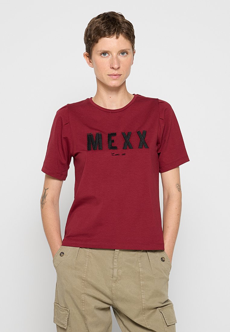 Bordeaux T-Shirt mit kurzen Ärmeln, auf der Vorderseite mit schwarzem "MEXX"-Schriftzug. Das Material wirkt weich; der Ausschnitt ist rund.