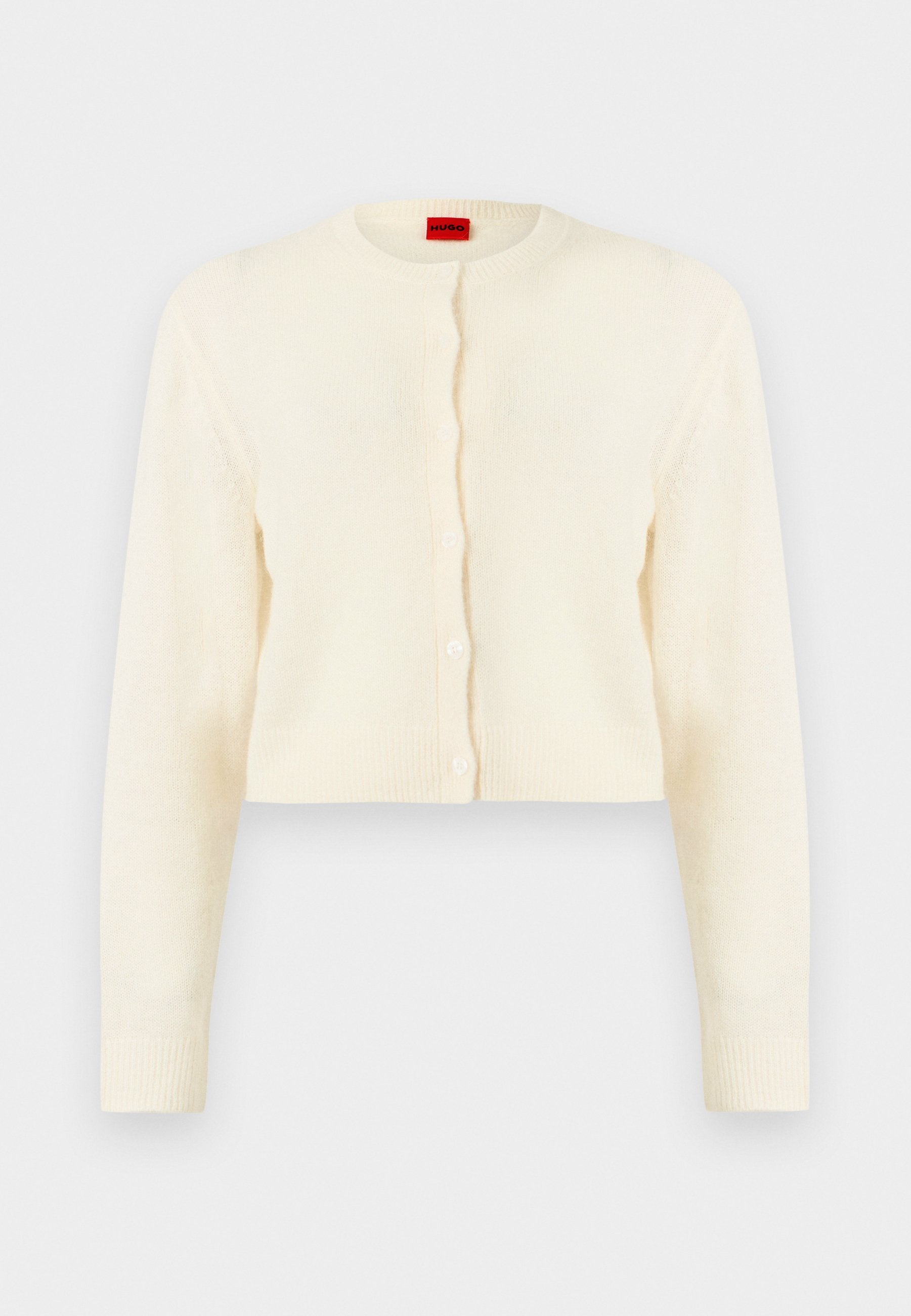 Cremefarbener, kurz geschnittener Cardigan mit rundem Ausschnitt, langen Ärmeln und Vorderknöpfen, mit rotem Markenlabel im inneren Kragen.