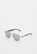 Sonnenbrille mit silbernem Metallrahmen, grauen Gläsern und dunkelblauen Bügeln, mit rotem Hugo-Logo an der Seite.