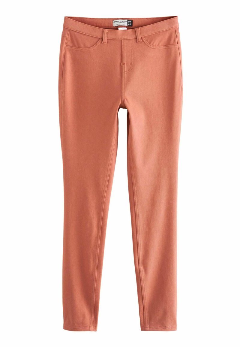 Schmal geschnittene, lange Leggings in gedämpftem Terrakotta mit Gürtelschlaufen, Fronttaschen und sichtbaren Nähten.