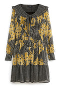Schwarzes Langarmkleid mit gelbem Blumenmuster, Rautendesign, Rüschkragen und Bindeband am Ausschnitt. Geraffte Taille und geschichteter Saum.