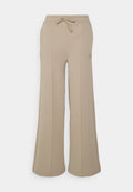 Beige weit geschnittene Sweatpants mit elastischem Bund und Kordelzug, ausgestattet mit seitlichen Nähten und einem kleinen, markierten Patch an der linken Hüfte.