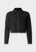 Schwarze, kurz geschnittene Jacke mit Reißverschluss vorne, langen Ärmeln und zwei Brusttaschen; aus glattem, strukturiertem Stoff.