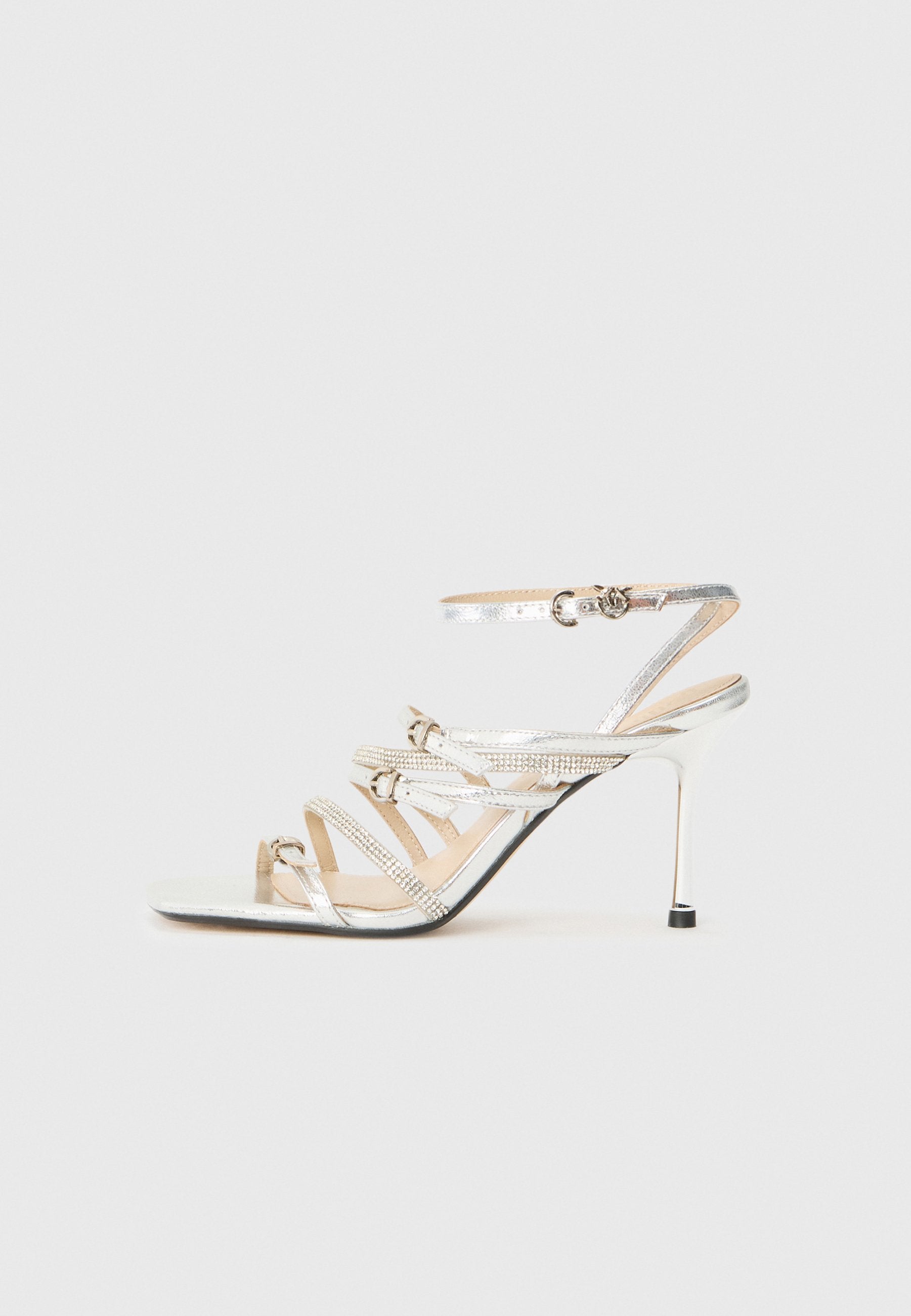 Silberne Sandalen mit Absatz, die mehrere überkreuzte Riemen, eine metallische Oberfläche und Strassakzente aufweisen. Offenes Zehendesign mit schlankem Stiletto-Absatz.