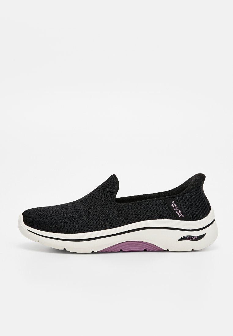 Schwarzer Slip-on-Sneaker mit weißer und lila Sohle, atmungsaktivem Mesh-Obermaterial und markierter Fußgewölbestütze, die an der Ferse sichtbar ist.