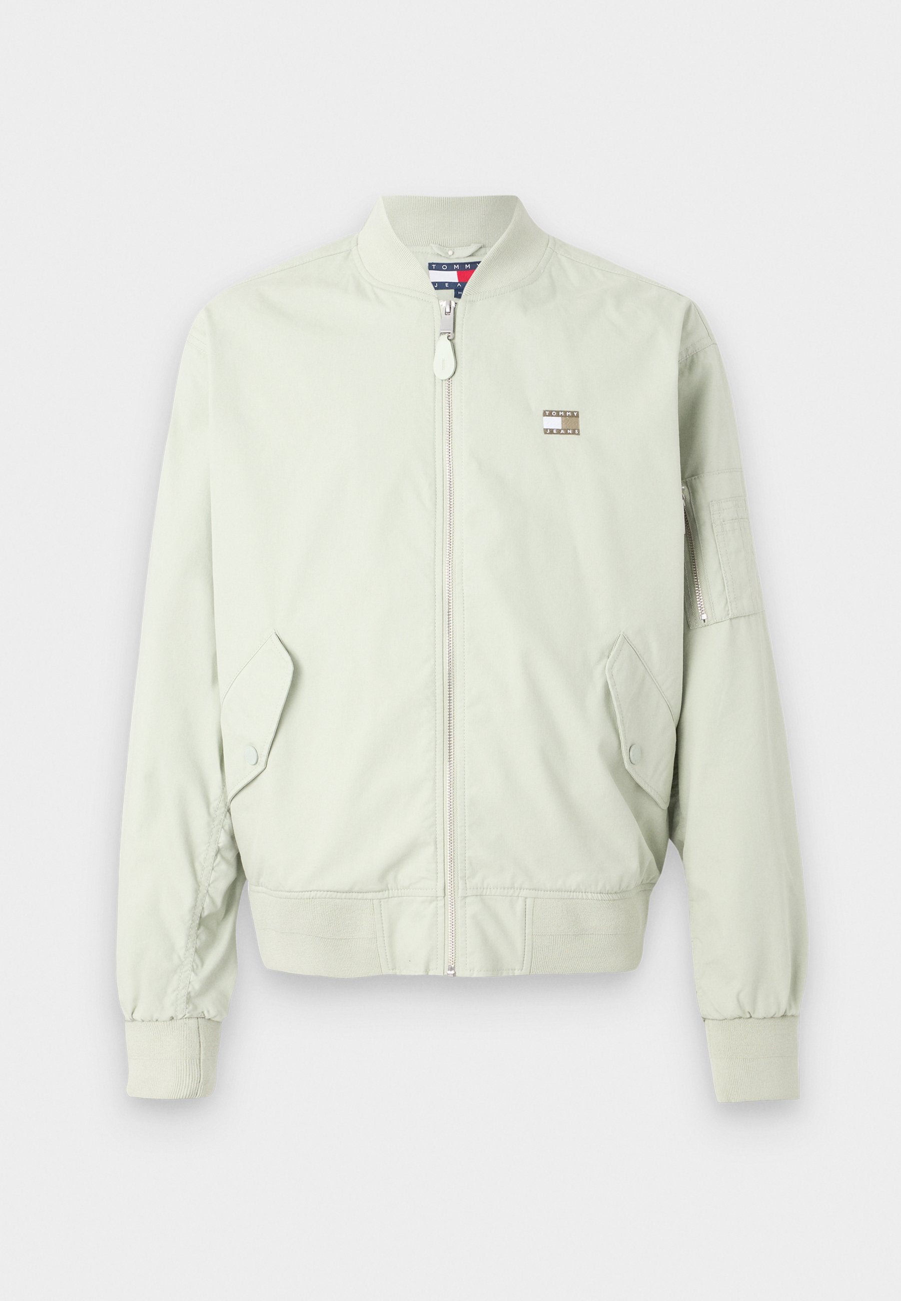 Hellgrüne Bomberjacke aus glattem Material; mit einem Frontreißverschluss, gerippten Bündchen, zwei Seitentaschen und einem kleinen Logo-Patch auf der Brust.