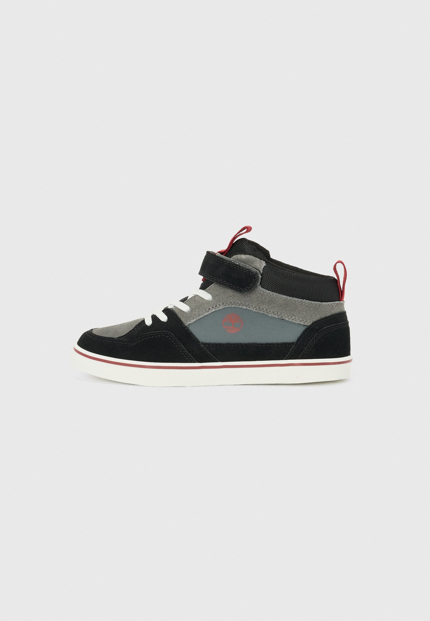 Hochformat Sneaker aus schwarzem und grauem Wildleder, ausgestattet mit einem Klettverschluss, weißen Schnürsenkeln, roten Akzenten und einer Gummisohle mit einem kontrastierenden Rand.
