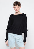 Schwarzer, oversized Strickpullover mit weitem Halsausschnitt, langen Ärmeln und elastischem Saum. Tragen mit hellblauen Jeansshorts.