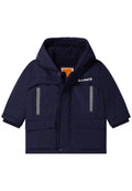 Dunkelblaue Kinder-Winterjacke mit Kapuze, Fronttaschen, reflektierenden Streifen und Timberland-Logo auf der Brust.