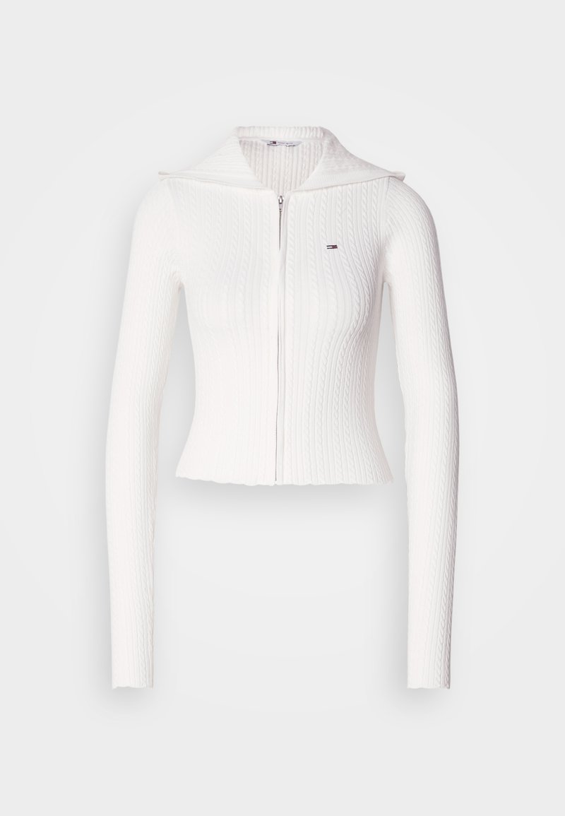 Weißer gerippter Strick-Zip-Pullover mit langen Ärmeln und umgeschlagenem Kragen. Enthält ein kleines Logo auf der linken Brust. Cropped-Design.