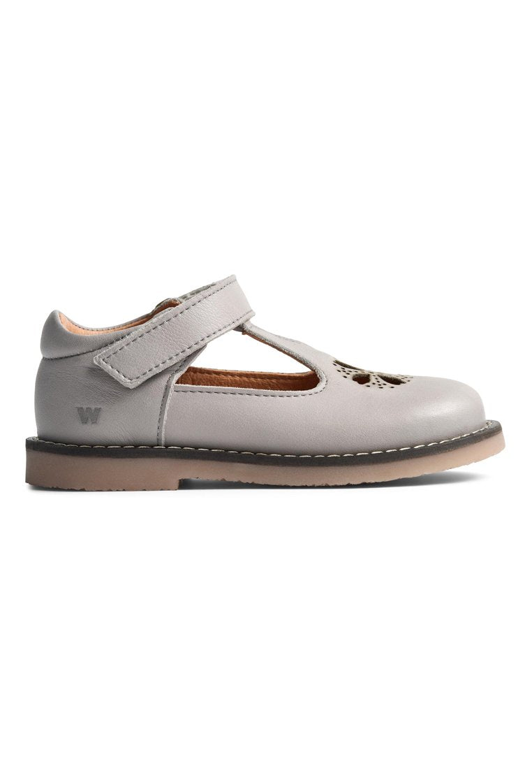 Grauer Leder-Mary-Jane-Schuh mit Klettverschluss, Ausschnitt-Details und einer beigefarbenen Gummisohle. Gestickte Akzente entlang des Randes.