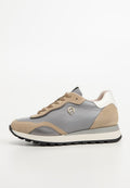Graue und beige Sneaker aus Wildleder und Leder, mit Schnürdesign, kontrastierenden weißen Akzenten und strukturierten Details an der Seite.