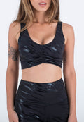 Schwarzes athletisches Crop-Top mit glänzendem, strukturiertem Zebramuster, ausgestattet mit einem U-Boot-Ausschnitt und gerafften Details an der Vorderseite.