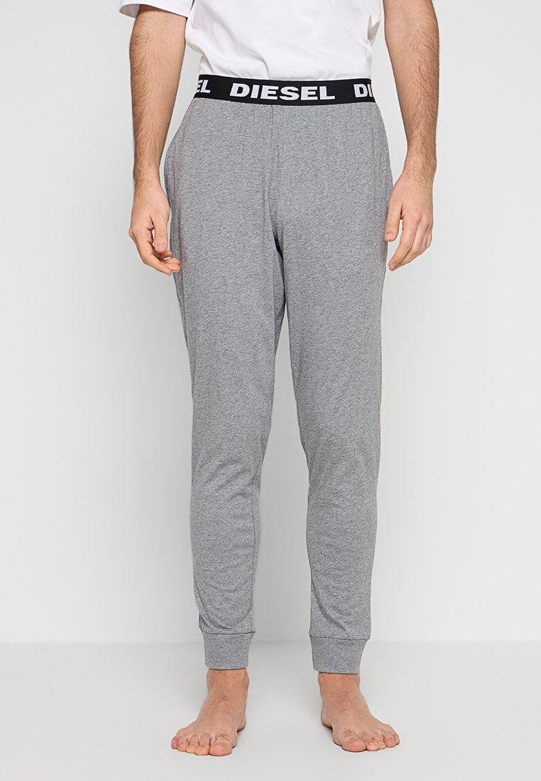 Graue Jogginghosen aus weichem Stoff, mit einem schwarzen Bund und dem Schriftzug "DIESEL". Eng anliegendes Design mit zulaufenden Beinen und gerippten Bündchen.