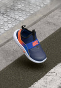 Nike Slipper in Marineblau mit leuchtend orangefarbenen Akzenten, ausgestattet mit einer strukturierten Oberseite, elastischem Riemen und einer weißen Sohle; minimalistisches Design.