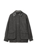 Grau meliertes Jacket mit einem schwarzen Lederkragen, zwei aufgesetzten Fronttaschen, elastischem Saum und einem strukturierten Fischgrätmuster.