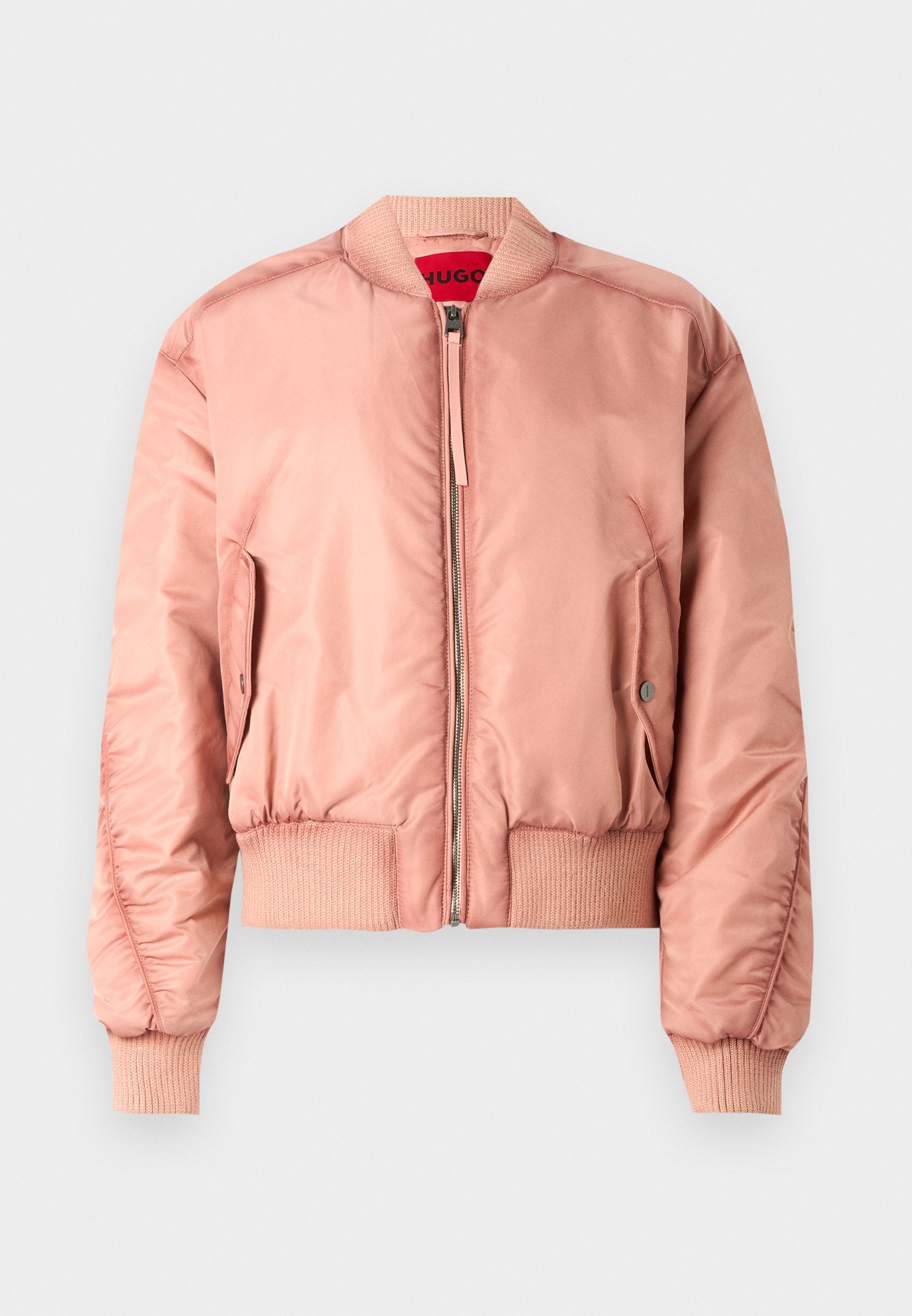 Pinkfarbige Bomberjacke aus glattem, glänzendem Material. Mit gerippten Bündchen und Saum, Reißverschluss und Seitentasche. Rote Innenfutter.