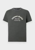 Graues Baumwoll-T-Shirt mit kurzen Ärmeln, rundem Ausschnitt und weißem gesticktem Text: "TOMMY JEANS SINCE 1985 New York City" auf der Vorderseite.