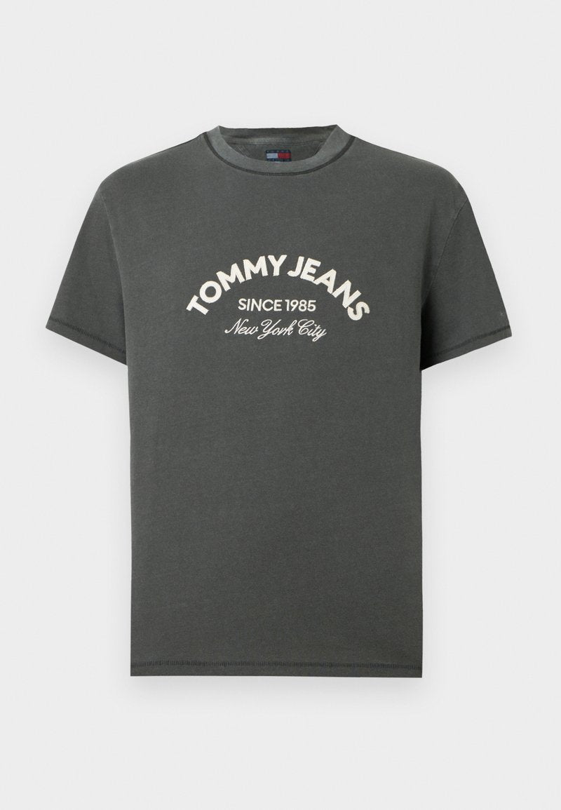 Graues Baumwoll-T-Shirt mit kurzen Ärmeln, rundem Ausschnitt und weißem gesticktem Text: "TOMMY JEANS SINCE 1985 New York City" auf der Vorderseite.