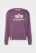 Lila Sweatshirt mit einem vorderen Logo "ALPHA INDUSTRIES" in Weiß, gerippten Bündchen und einem roten Etikett mit dem Detail "REMOVE BEFORE FLIGHT".