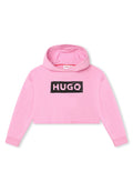 Rosa verkürzter Kapuzenpullover aus weichem Stoff mit einem großen schwarzen "HUGO"-Logo auf der Vorderseite und gerippten Bündchen. Rohschnitt-Detail am Saum.