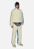 Hellbeige und blaue Trainingsanzug mit Reißverschlussjacke und lockeren Hosen. Enthält eine Gürteltasche mit "DIESEL"-Logo und strukturierten Sneakers.