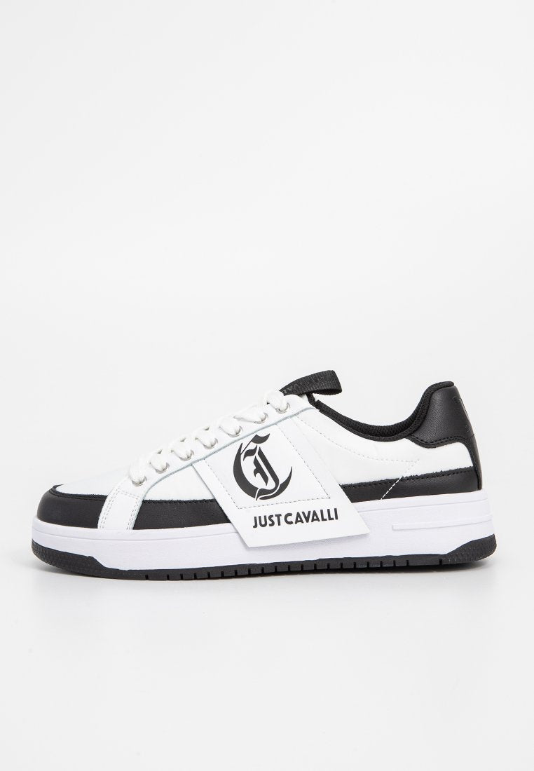 Weiße Sneaker mit schwarzen Akzenten, Schnürdesign, strukturiertem Leder und einem Logo-Patch an der Seite. Verfügt über eine robuste Gummisohle.
