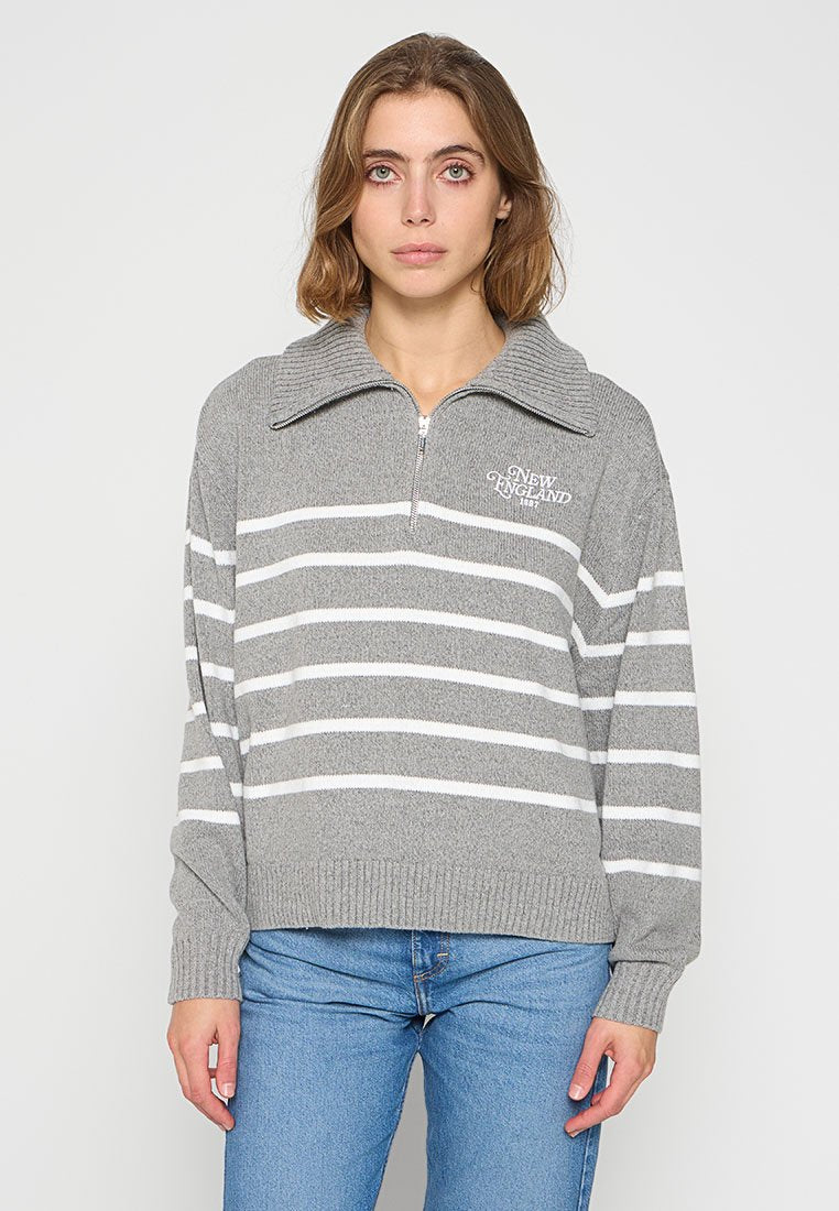 Grauer Strickpullover mit weißen horizontalen Streifen, hohem Kragen und Reißverschluss vorne. Enthält bestickten Text auf der Brust.