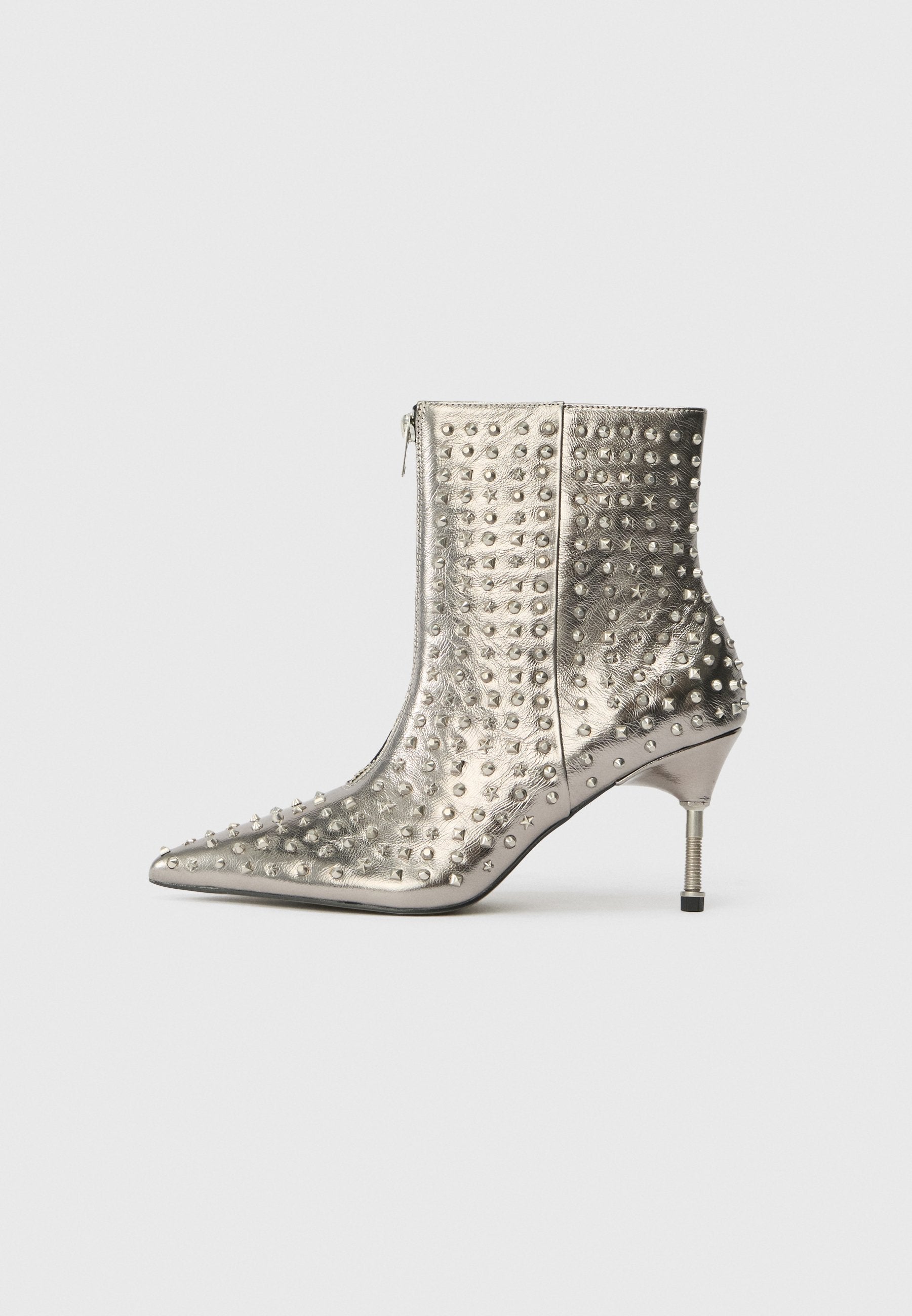 Silberner Knöchelboot mit spitzem Zeh, genoppter Textur, metallic Finish und schmalem, zylindrischem Absatz. Seitenzipper zum Schließen.