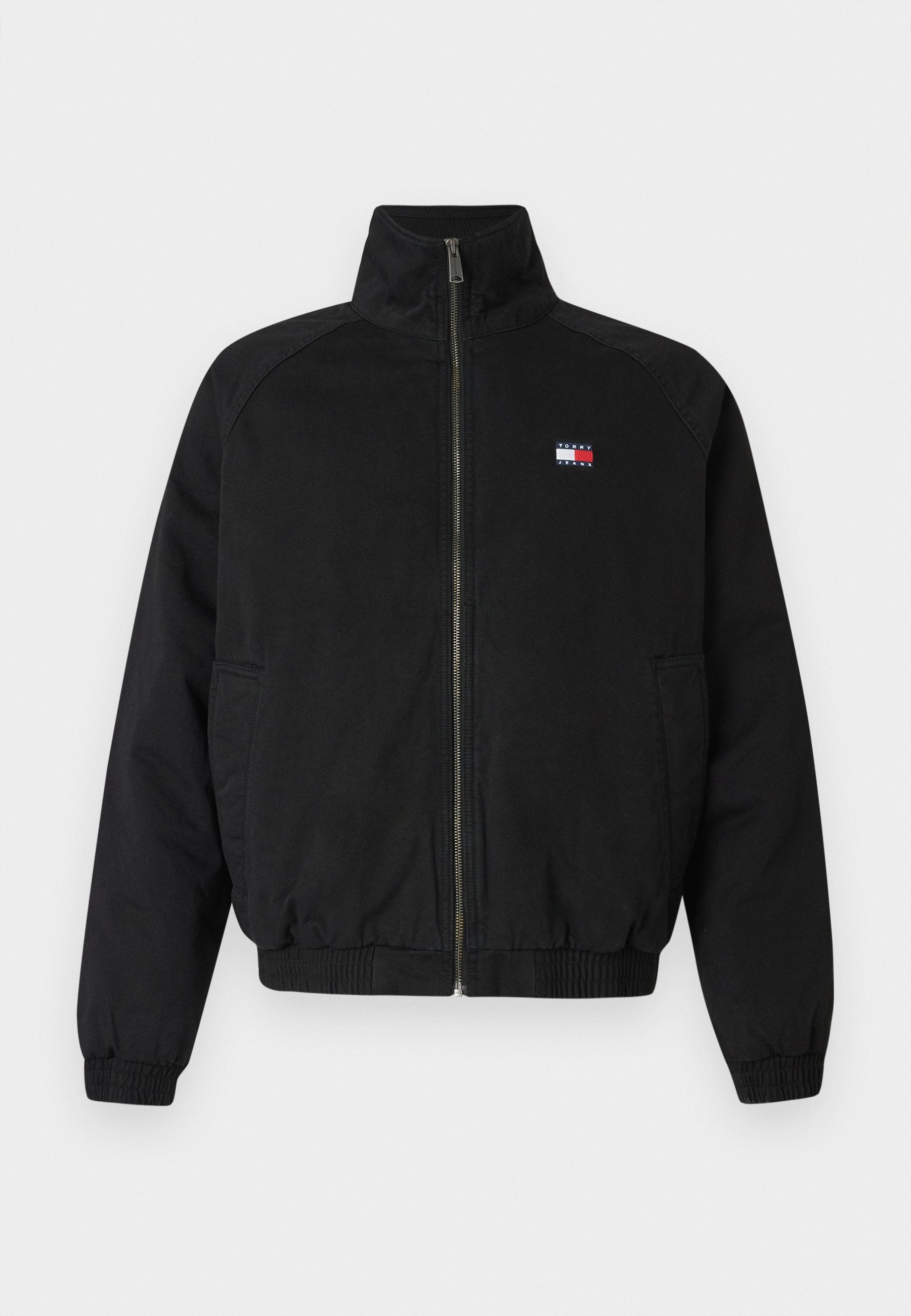 Schwarze Bomberjacke mit hohem Kragen, Frontreißverschluss, elastischen Bündchen und Saum, mit einem kleinen Logo in Rot, Weiß und Blau auf der Brust.