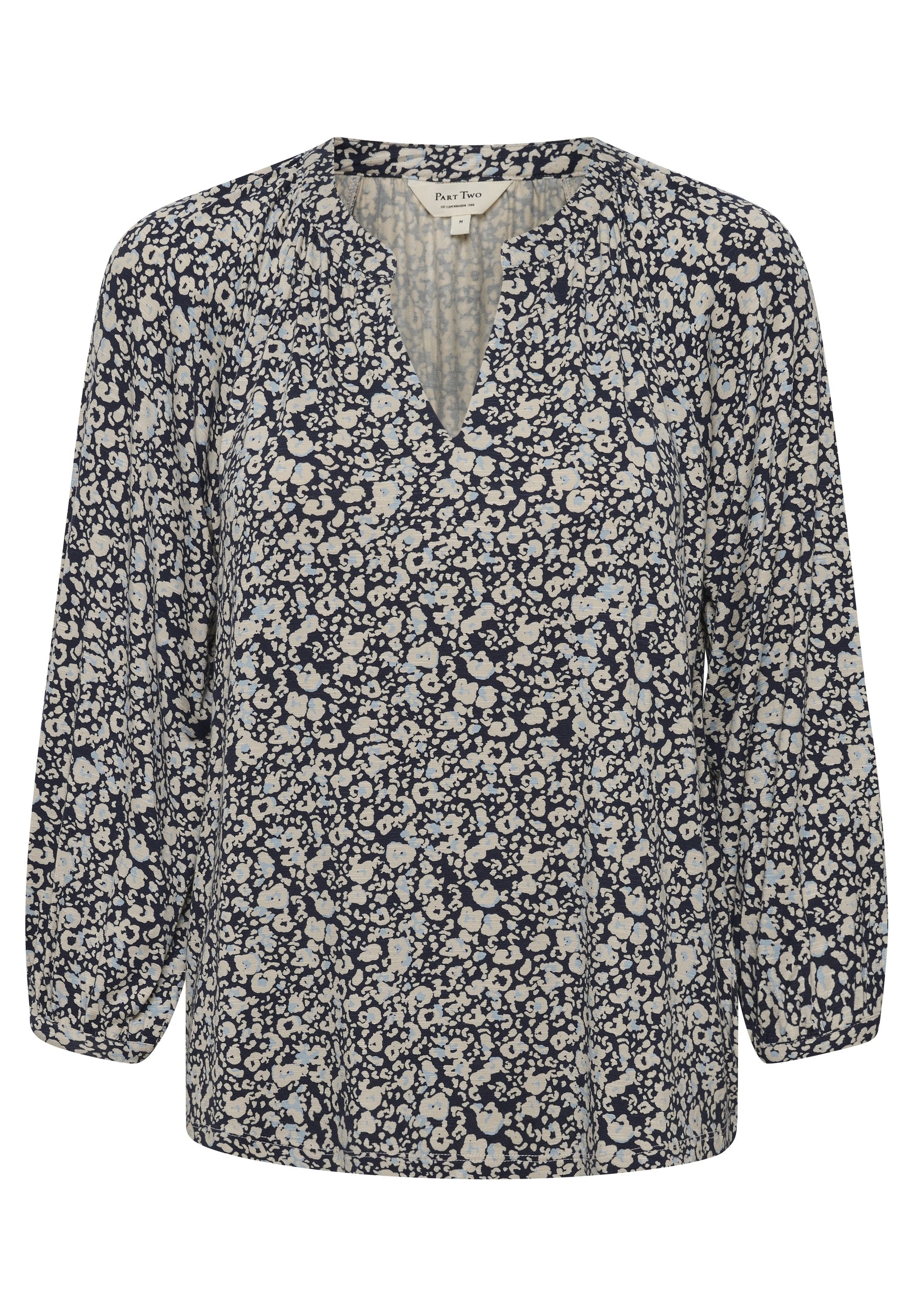Marineblaue Bluse mit V-Ausschnitt, langen Ärmeln und lockerer Passform. Ausgestattet mit hellblauen und cremfarbenen Blumenmustern auf einem strukturierten Stoff.