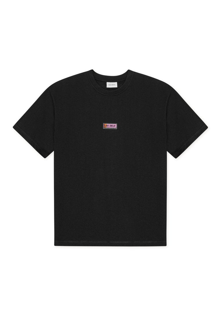 Schwarzes T-Shirt mit kurzen Ärmeln und einem kleinen rechteckigen "LES DEUX" Logopatch mittig auf der Brust.