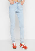 Helle blaue High-Waisted-Jeans mit schlanker Passform, klassischem Fünf-Taschen-Design und dezentem ausgewaschenem Look. Getragen mit roten Sneakers.