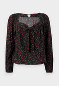 Schwarze Bluse mit Blumenmuster und langen Ärmeln, vorne mit Bindeband, gerafften Details und kleinen roten und weißen Blumenmustern auf der gesamten Fläche.